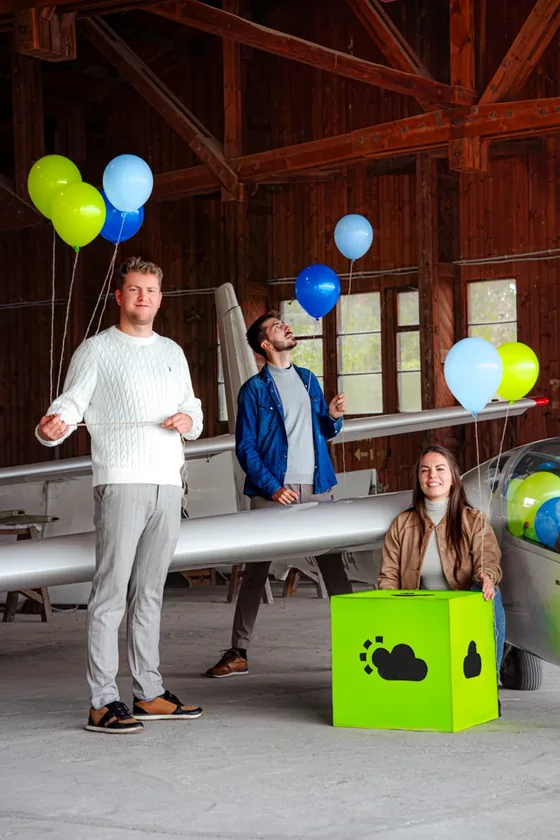 Sesja zdjęciowa High-Flyer — mężczyzna z balonami i limonkowym pudełkiem z logo HF